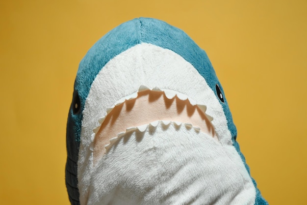 Requin en peluche bleu sur fond jaune