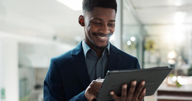 Réseau de tablettes et homme d'affaires au bureau tapant un message sur Internet ou une application mobile Chat technologique numérique et avocat africain défilent sur les médias sociaux ou le site Web sur le lieu de travail