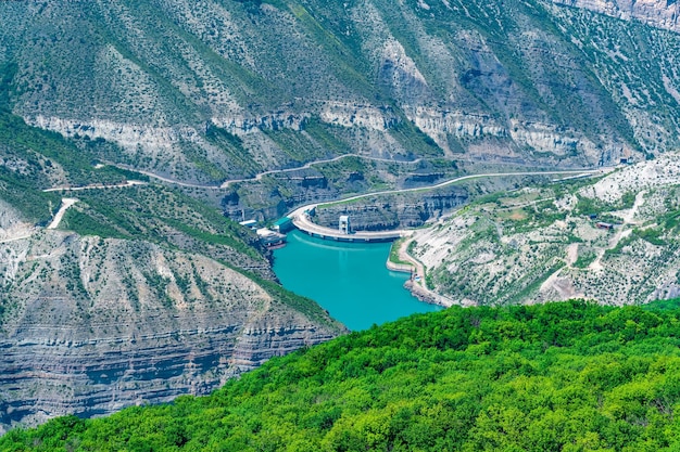 Réservoir dans un canyon de montagne et partie supérieure du barrage-voûte d'une centrale hydroélectrique