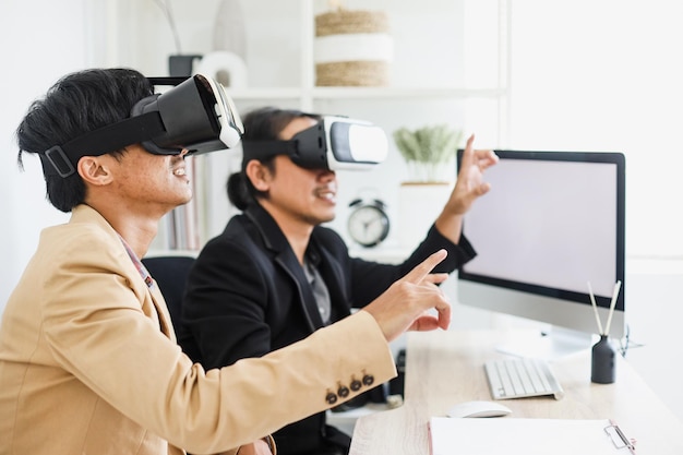 Responsable informatique faisant l'expérience de la réalité virtuelle au bureau avec un partenaire utilisant les dernières lunettes VR
