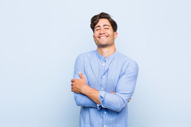 ressemblant à un artiste heureux, fier et satisfait souriant avec les bras croisés