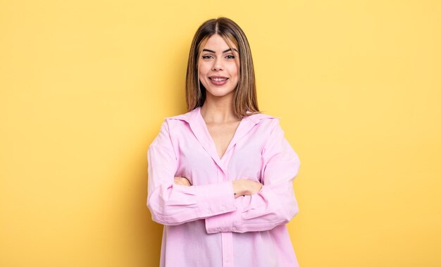 Ressemblant à un heureux accomplisseur fier et satisfait souriant avec les bras croisés