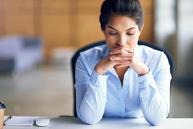 Ressentir la pression Photo d'une jeune femme d'affaires qui a l'air stressée alors qu'elle est assise à son bureau