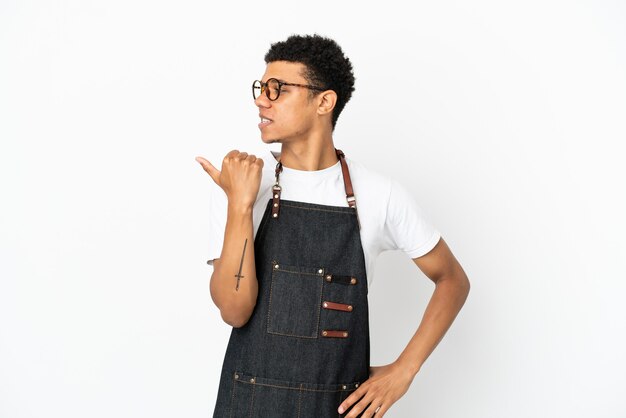 Restaurant African American waiter man isolé sur fond blanc pointant vers le côté pour présenter un produit