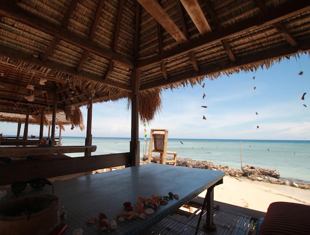 Un restaurant en bord de plage avec une vue sur la plage et une plage en arrière-plan.