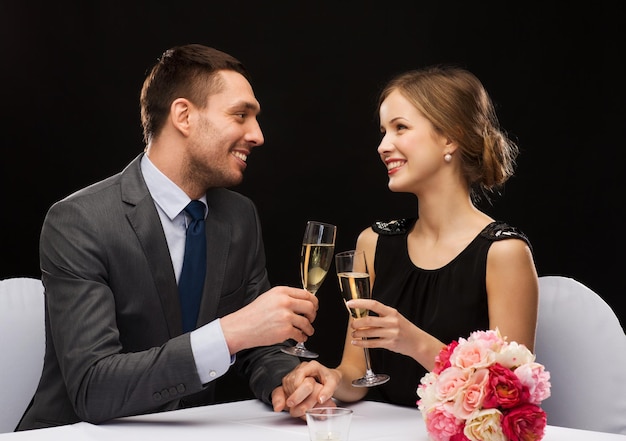 restaurant, couple et concept de vacances - couple souriant avec une coupe de champagne se regardant au restaurant