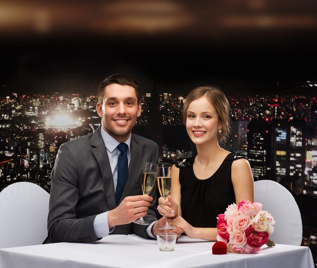 restaurant, couple et concept de vacances - couple souriant avec une coupe de champagne se regardant au restaurant