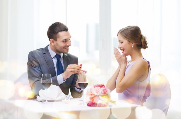 restaurant, couple et concept de vacances - homme souriant proposant à sa petite amie au restaurant
