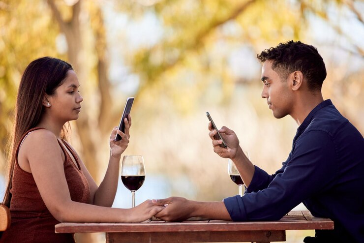 Photo restaurant date et couple lecture avec le téléphone sur le site de médias sociaux et le silence au dîner en ligne les gens et se détendre au café en été en vacances vacances et faire défiler internet en se tenant par la main