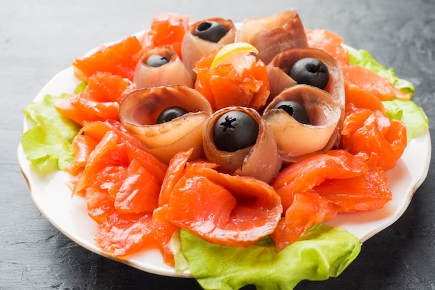 Restaurant gastronomique servant une assiette de sel fumé, filets de poisson blanc cru et saumon