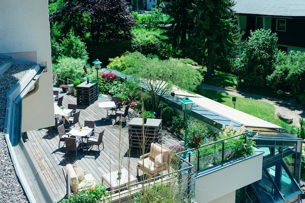 Restaurant de rue avec tables et chaises à l'hôtel resort de Bad Kleinkirchheim en Carinthie, Autriche. Conception d'un café-terrasse. Mode de vie et nature. Terrasse ou véranda de café prête pour le petit déjeuner
