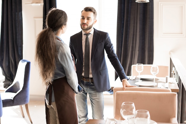 Restaurateur confiant à l'écoute de la serveuse