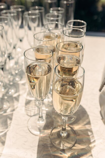 Restauration de belles coupes de champagne avec des bulles sur la table au soleil servant une fête de mariage