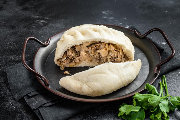 Restauration rapide nationale coréenne tartes cuites à la vapeur pyanse Pyanse avec légumes et viande Fond noir Vue de dessus