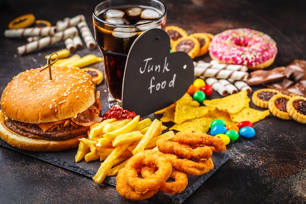 Restauration rapide et sucre. Burger, bonbons, chips, chocolat, beignets, sodas.