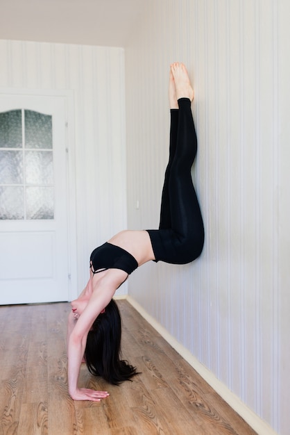 Rester en forme et en bonne santé. Belle jeune femme en vêtements de sport faisant du yoga tout en se relaxant à la maison