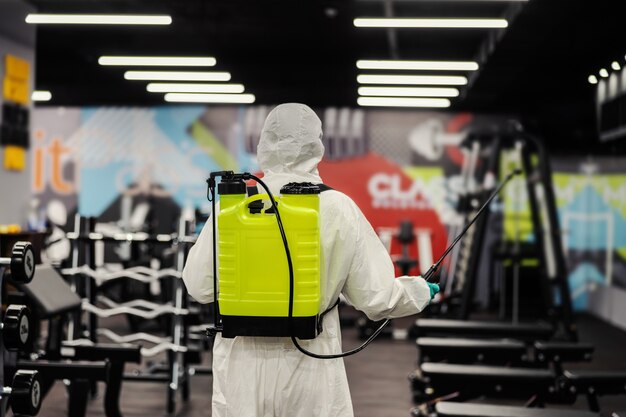 Restez en bonne santé avertissement pour COVID 19 L'homme dans un uniforme de protection empêche la propagation de l'infection