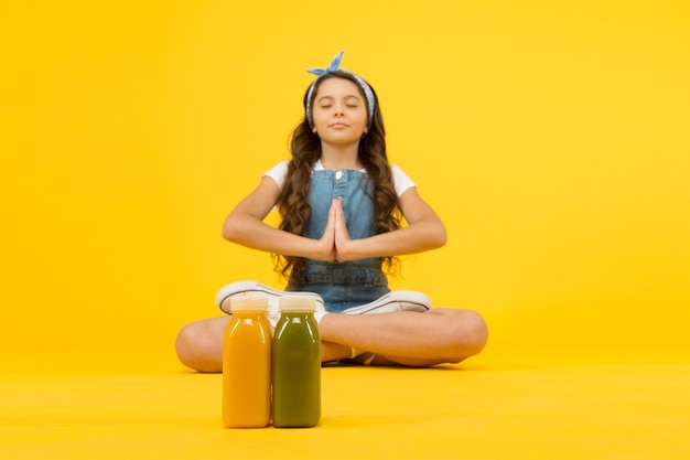 Restez positif et optimiste. Mode de vie sain. Formation de yoga. KId girl s'asseoir méditer. Pratique de la méditation. Ondes positives. Méditer paisiblement. Boisson smoothie végétarienne. Apprenez les techniques de méditation.