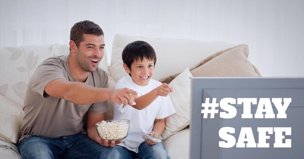 Restez en sécurité texte sur père et fils en regardant la télévision et en mangeant du pop-corn
