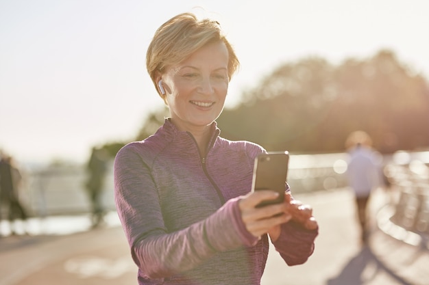 Les résultats parlent d'eux-mêmes portrait d'une femme mature active et joyeuse en vêtements de sport l'utilisant