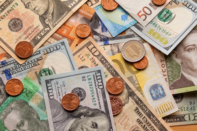 Photo résumé coloré composé de différentes pièces de métal, de billets américains, ukrainiens et de billets en euros. argent et finances, concept d'investissement réussi.