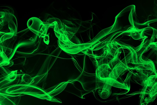 Résumé de fumée verte sur fond noir et concept d'obscurité