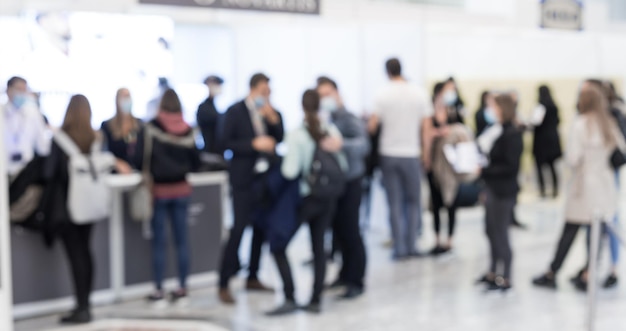 Résumé des personnes estompées dans le hall d'exposition du salon de l'événement expo. Salon de la convention d'affaires ou salon de l'emploi. Fond de concept d'entreprise.