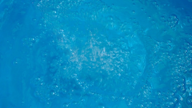 Résumé avec surface de l'eau avec des bulles sur fond bleu.