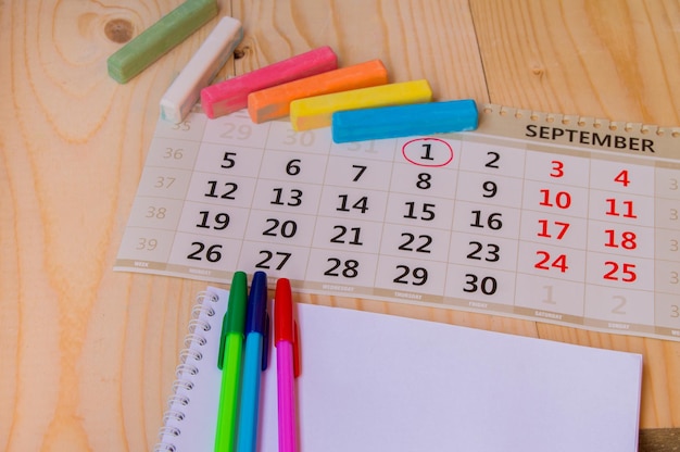 Retour au calendrier scolaire craie de couleur sur fond de bois