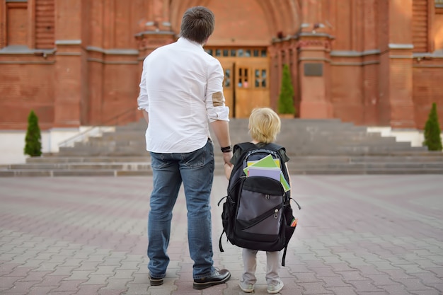 Retour au concept de l'école. Petit élève avec son père. Premier jour d'école primaire.