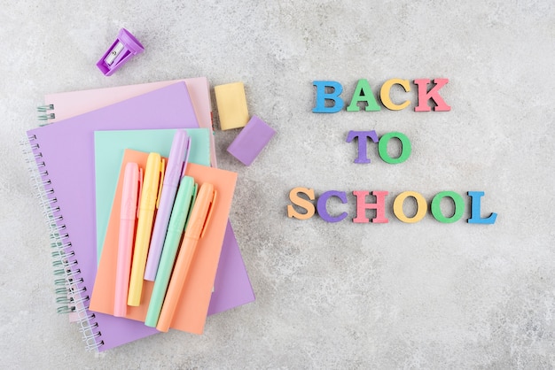 Photo retour au fond de l'école avec des cahiers et des stylos colorés