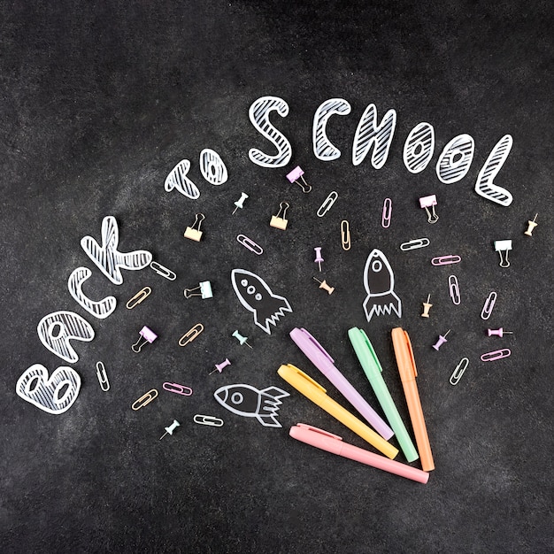 Photo retour au fond de l'école avec des fournitures scolaires sur tableau noir