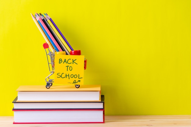 Retour Aux Fournitures Scolaires. Livres Et Fond Jaune Sur Une Table En Bois