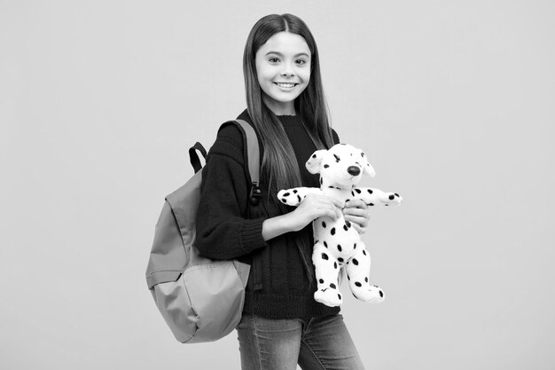 Retour à L'école Adolescent écolière Tenir Livre Avec Jouet Prêt à Apprendre Les Enfants De L'école Sur Fond De Studio Jaune Isolé