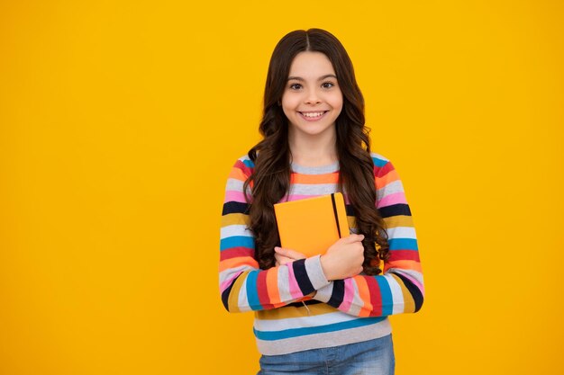 Retour à l'école Adolescente écolière avec livre prêt à apprendre Écolières sur fond de studio jaune isolé Heureux adolescent émotions positives et souriantes de l'adolescente