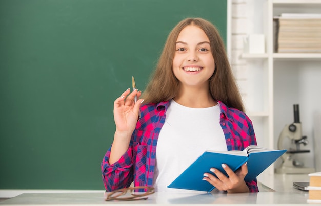 Retour à l'école. adolescente prête à étudier. enfant fait ses devoirs avec un livre. étudiant adolescent. éducation moderne. lycée. écolière avec cahier. espace de copie. enfant gai prenant des notes dans un cahier.