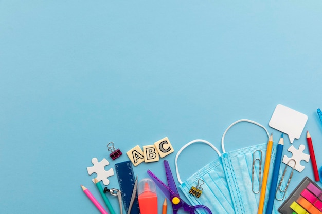 Retour à l'école concept fournitures scolaires avec un masque médical