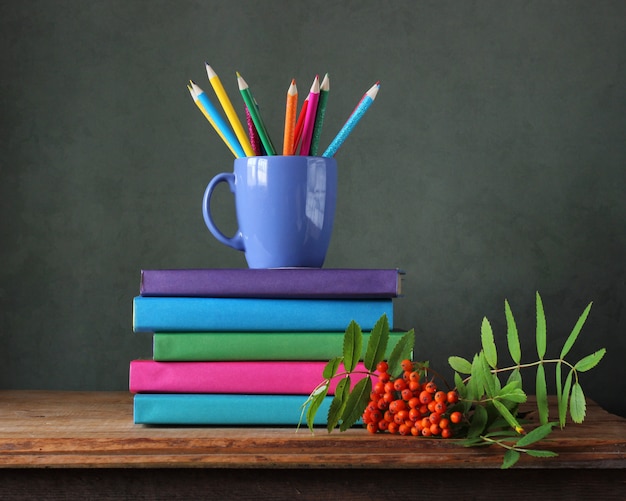 Retour à l'école. Crayons de couleur, manuels scolaires et bouquet de Rowan sur la table.