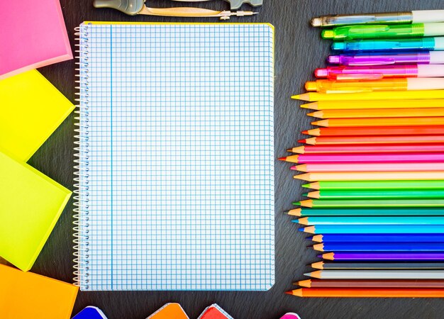 Photo retour à l'école crayons et stylos arc-en-ciel et réglé cahier rétro tonné