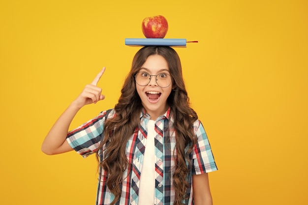 Retour à l'école écolière adolescente avec pomme sur la tête prête à apprendre les écoliers isolés