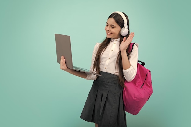 Retour à l'école Écolière adolescente en uniforme scolaire avec casque sac à dos et ordinateur portable
