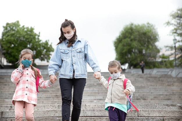 Retour à l'école. Les enfants atteints de la pandémie de coronavirus vont à l'école avec des masques. Relations amicales avec ma mère.