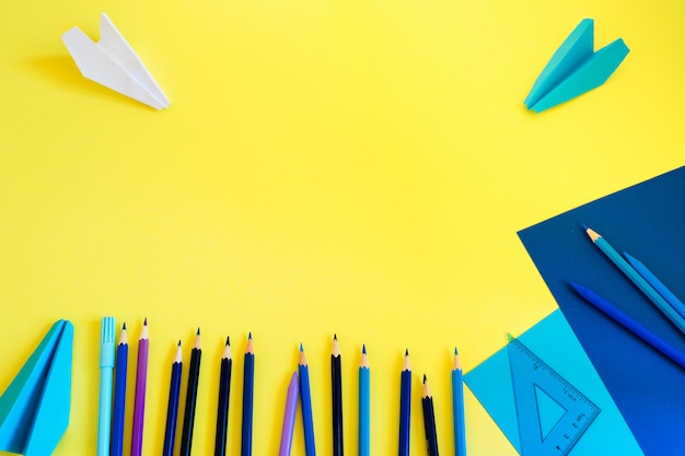 Photo retour à l'école. espace de travail créatif, à la mode, minimaliste, à l'école ou au bureau avec des fournitures bleues sur jaune