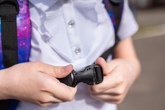 Retour à l'école Une fille en uniforme avec un parent va à l'école avec un sac à dos dans le dos