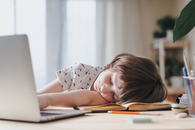 Retour à l'école. Garçon à la maison avec ordinateur portable