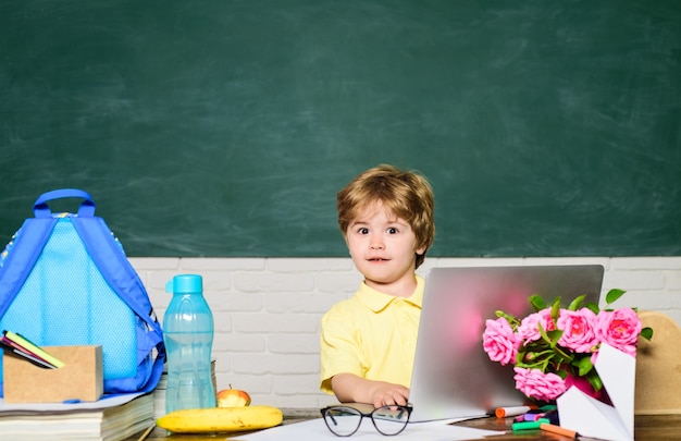 Retour à l'école garçon surpris travaillant avec un ordinateur portable elearning test en ligne leçons de devoirs école