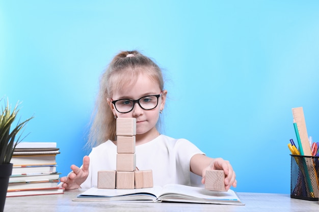 Retour à l'école. Heureux enfant industrieux mignon est assis à un bureau à l'intérieur. Kid apprend en classe.quarantaine.Kid apprend à la maison.