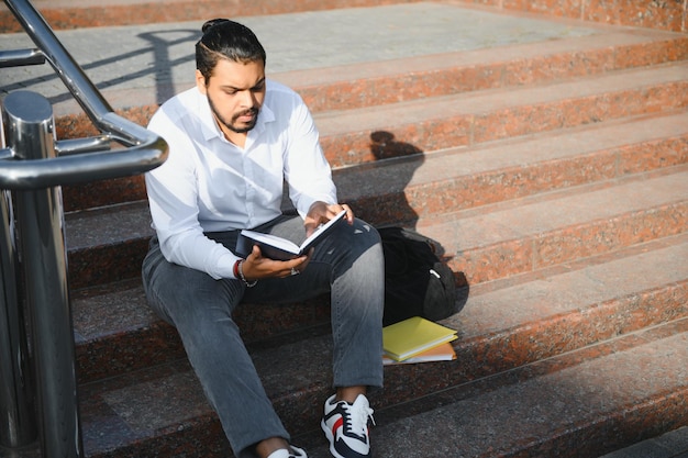 Retour à l'école Heureux étudiant intelligent indien ou arabe en vêtements élégants