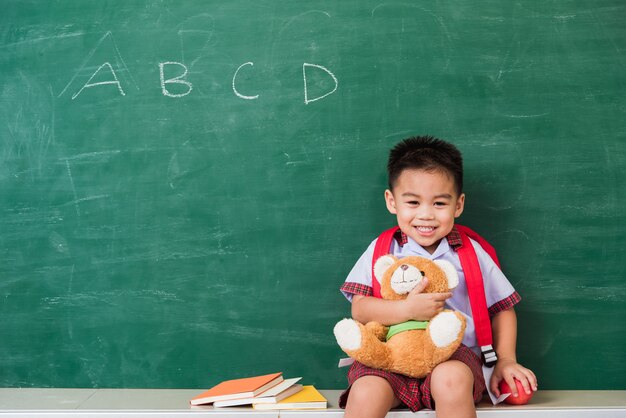 retour à l'école mignon petit garçon asiatique de la maternelle en uniforme d'étudiant avec sac d'école souriant