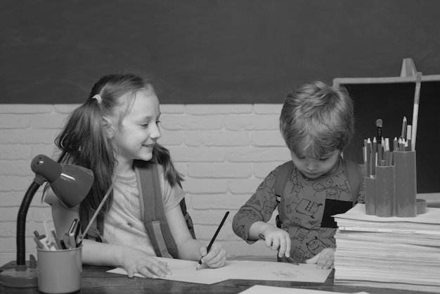 Retour à l'école mignon petit garçon enfant d'âge préscolaire avec petite fille enfant dans une classe écoliers